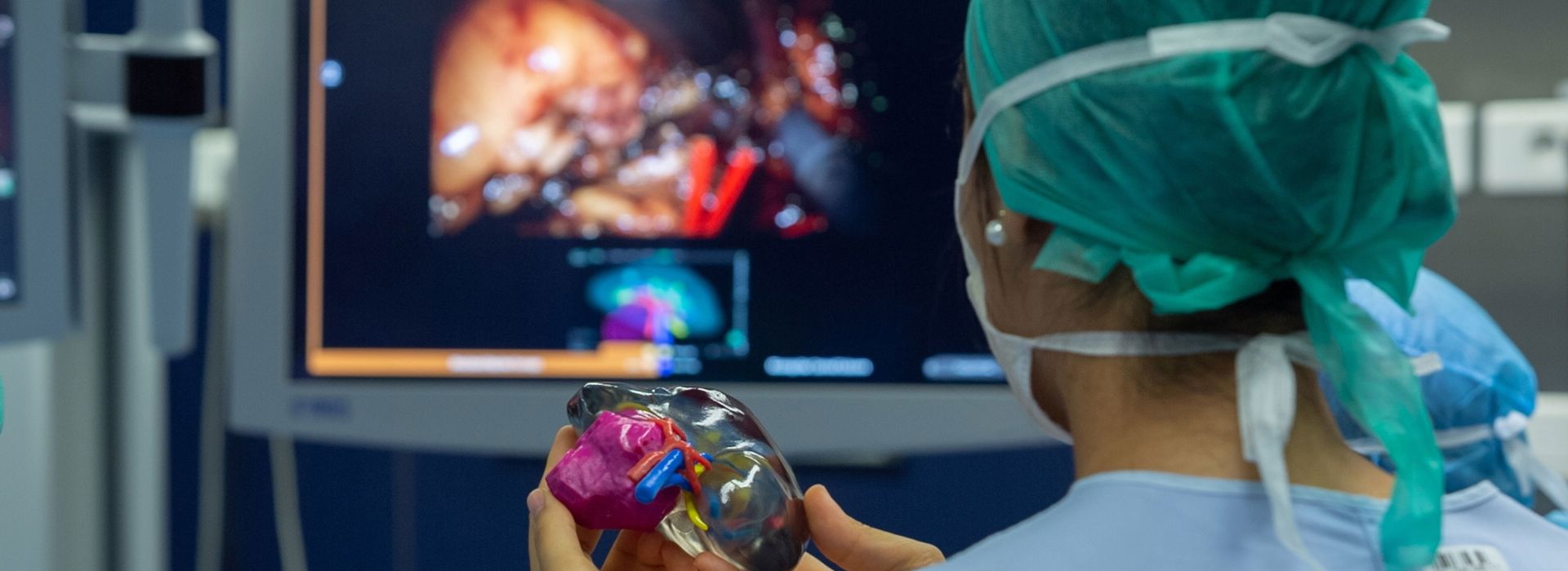 Trainee surgeon using a 3D printed model of a patient’s kidney in the operating theatre during a surgery.